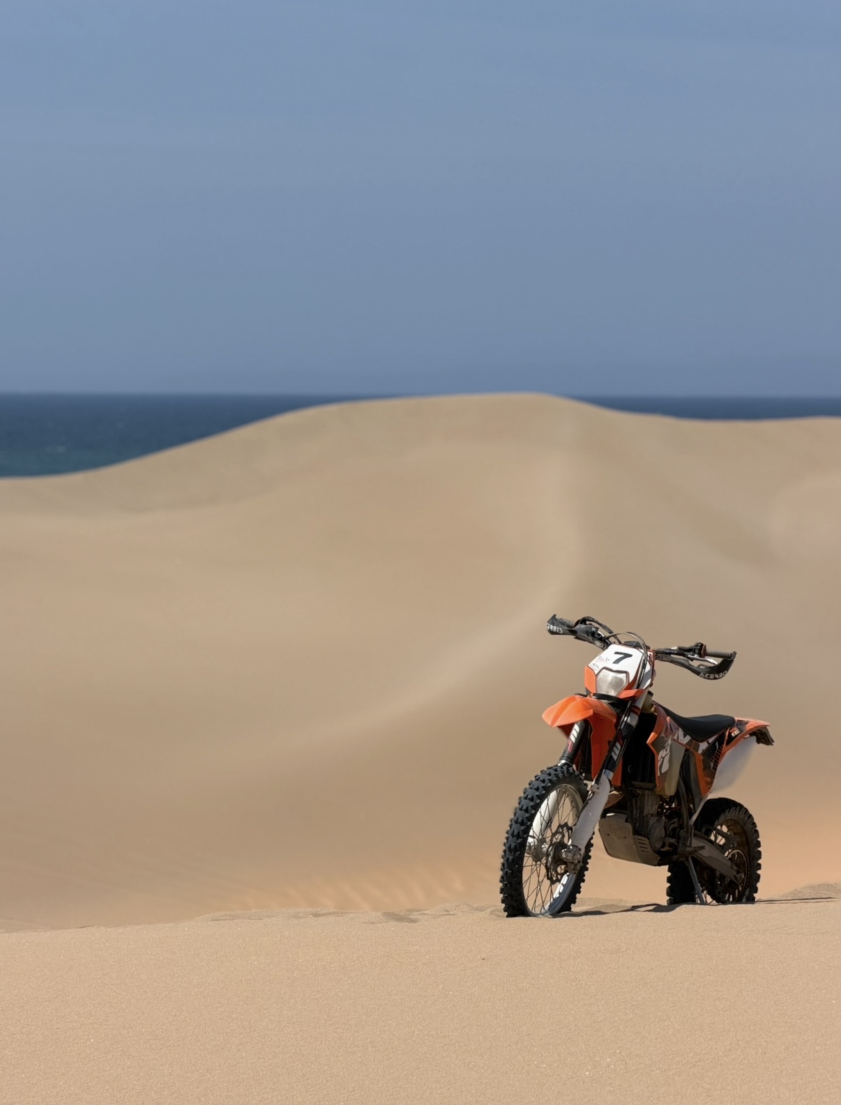 KTM 450 EXC-F sur dune face à l'océan — paysage d'Agadir